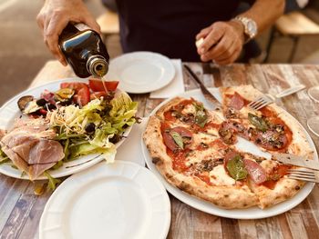 Midsection of man holding pizza on table