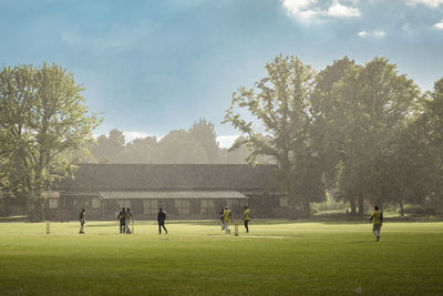 People in the rain on cricket field