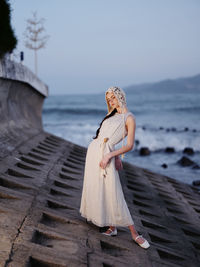 Rear view of woman standing at beach