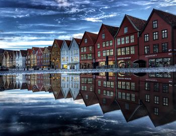 Reflection of houses on water against sky