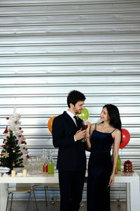 Young couple standing against glass wall