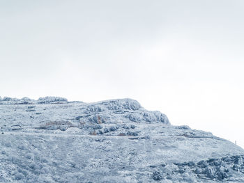 Low angle view of snowcapped mountain against clear sky