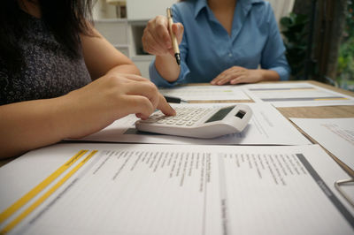 Midsection of students studying at office