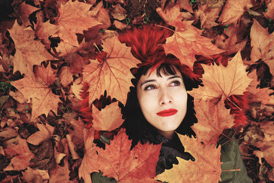 Portrait of young woman with autumn leaves