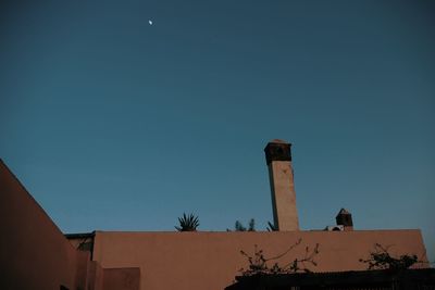 Low angle view of factory against clear blue sky