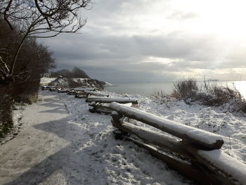 Scenic view of snow covered land against sky