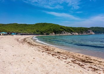 Scenic view of beach against blue sky