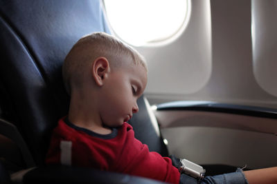 Close-up of boy sleeping in air plane