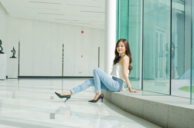 Portrait of young woman sitting by window