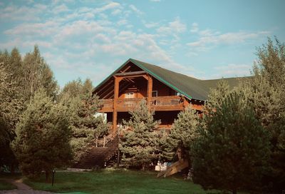 House amidst trees and buildings against sky