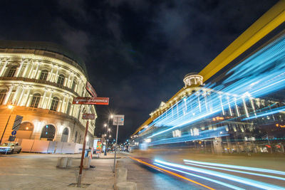 Light trails on road against buildings at night