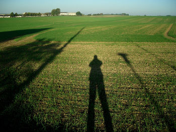 Shadow of man on grassy field