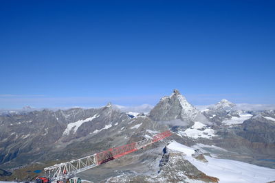 Scenic view of snowcapped mountains against clear blue sky