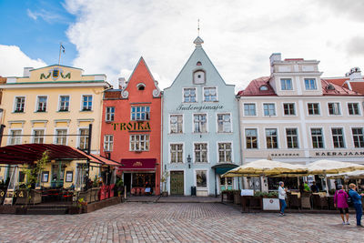 Buildings in city against cloudy sky