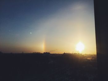 Silhouette trees on field against sky at sunset