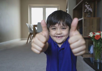 Portrait of smiling boy holding indoors