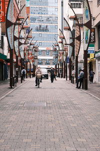 People on street amidst buildings in city