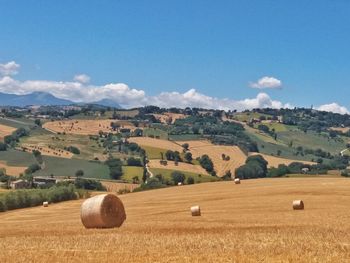 Hay bales on field against sky