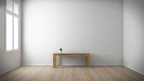 Empty chair on table against wall