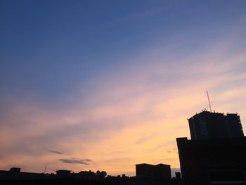 Low angle view of buildings against cloudy sky