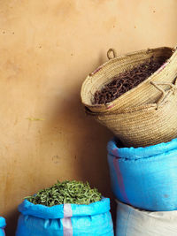 Dried leaves and vegetables in sack by wall