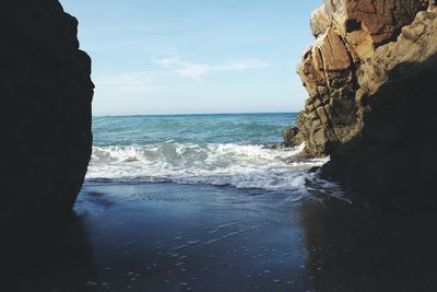 Rock formation in sea against sky