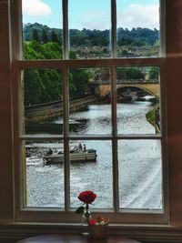 Boat sailing on canal seen through window