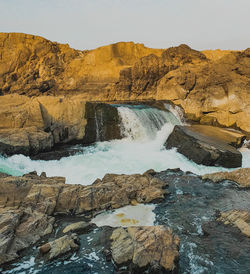 Scenic view of waterfall against sky