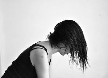 Side view of woman with wet hair against white background