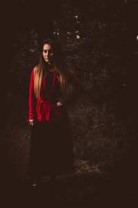 Full length of woman standing against wall