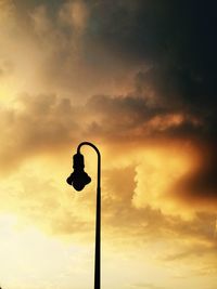 Low angle view of street light against cloudy sky