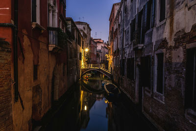 Bridge over canal amidst buildings in city