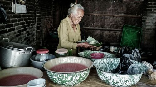 Senior woman selling food at market stall