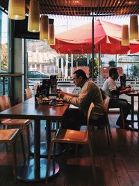 Woman sitting on table at restaurant