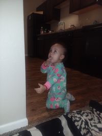 Cute girl sitting on floor at home