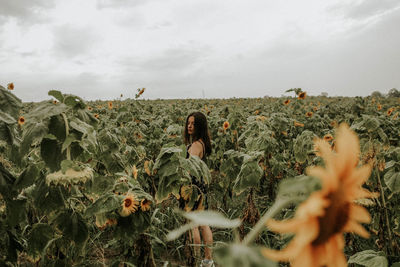 Young woman standing at sunflower farm