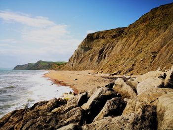 Rock formation on beach against sky