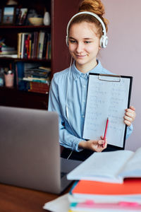 Girl having video call on laptop while studying at home