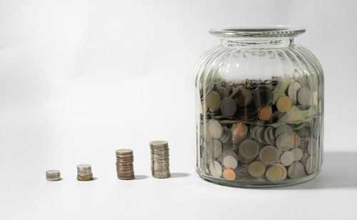 Close-up of coins on table against white background