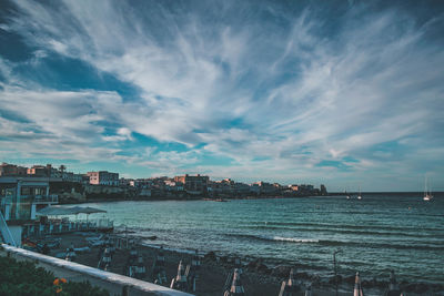 Panoramic view of sea and buildings against sky