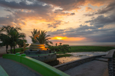 Scenic view of palm trees against sky during sunset