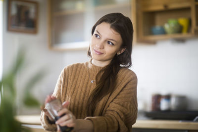 Portrait of a smiling young woman at home