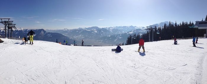 People skiing on snowcapped mountain against sky