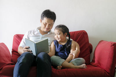 Happy friends sitting on sofa