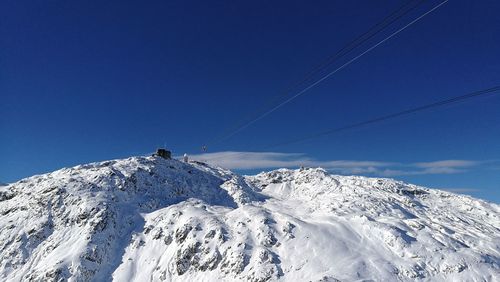 Low angle view of ski lift against blue sky