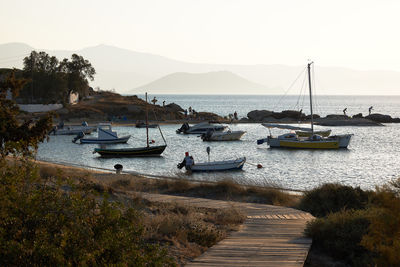 Sailboats moored on sea against sky