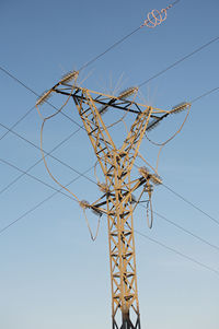 Low angle view of electricity pylon against sky