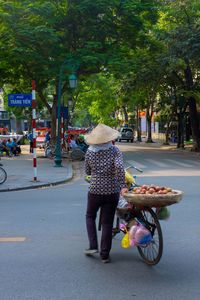 Rear view of woman riding bicycle on road