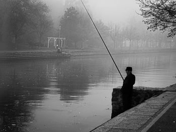 Rear view of man standing in lake