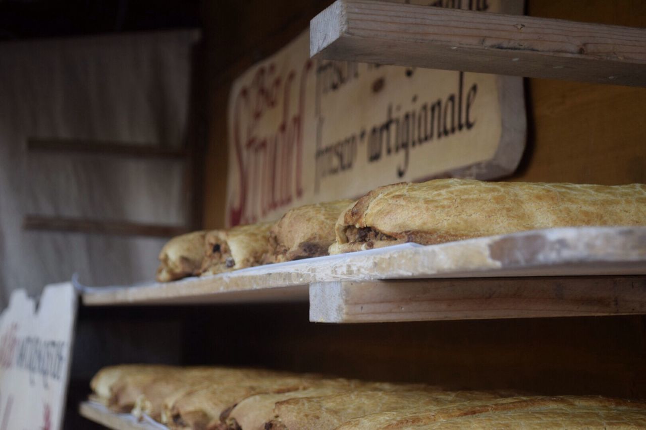 indoors, selective focus, close-up, food and drink, no people, wood - material, food, table, home interior, focus on foreground, text, still life, day, relaxation, brown, sleeping, animal themes, high angle view, book, bread